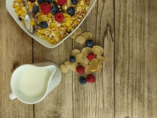 A top view of a bowl of fresh and delicious Granola and milk on a wooden table