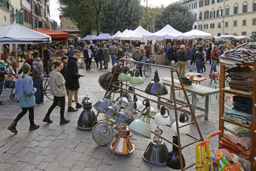7 January 2020 - Florence, Italy: People examine the display on a flea market in the center of Florence, Italy.