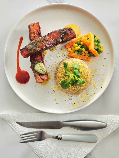 A dining plate with cutlery on a table