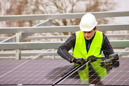 A construction worker installing solar panels in Germany