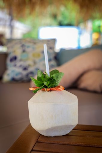 A selective focus shot of fresh coconut drink with drinking straw