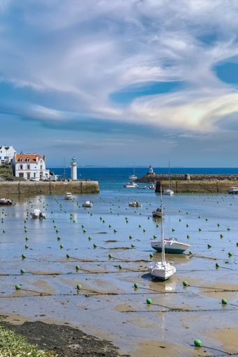 A scenic view of Sauzon in Brittany, the typical harbor with bots and a lighthouse