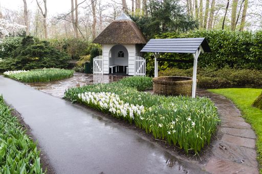 A beautiful view of a well surrounded by grass in the field in Keukenhof Lisse Netherlands