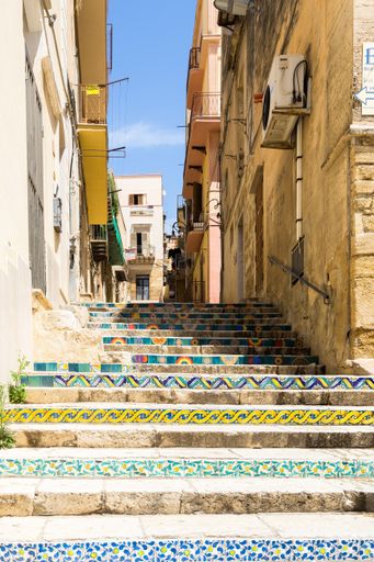 A beautiful shot of an alleyway and the colorful stairs in the old town of Sciacca, Sicily, Italy