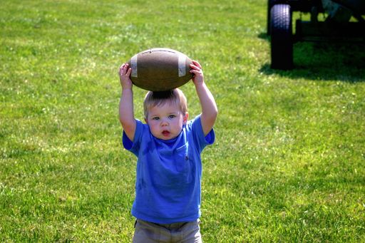 Toddler holds football on his head. Taken at Canale Farms.
