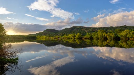 A beautiful scenery of green mountains reflecting on water in Matanzas city Cuba at sunrise