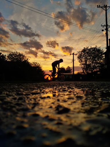 A beautiful shot of a young male kid riding his bicycle during sunset
