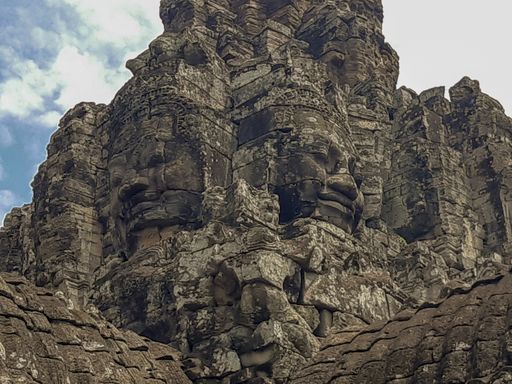 A low angle shot of the serene smiling faces carved on Bayon Temple in Siem Reap, Cambodia