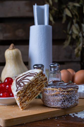 Two freshly baked cakes with different toppings on the table with baking ingredients on the background