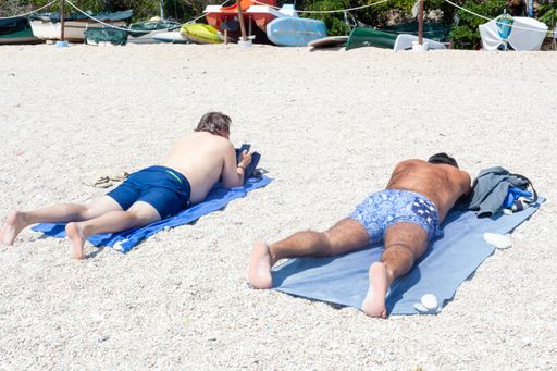 People , mostly italian local tourist, enjoys beach in summertime following distancing rules at the adriatic sea