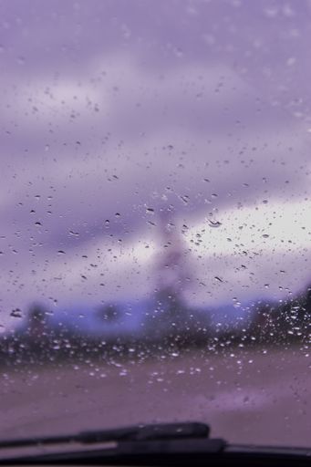A moody view of mountain landscape through a wet window after rain