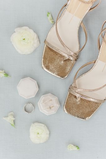 A top view of a bride's wedding shoes and accessories with flowers