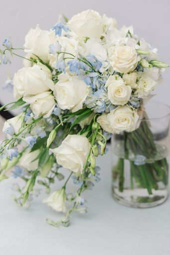 A vase with white and blue flowers on a table