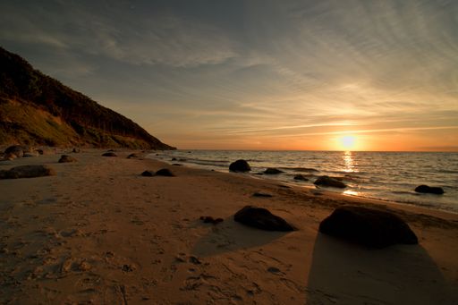 A scenic sunrise at the beach under wispy clouds
