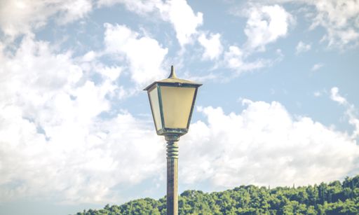 A close shot of a post lamp with cloudy sky in the background
