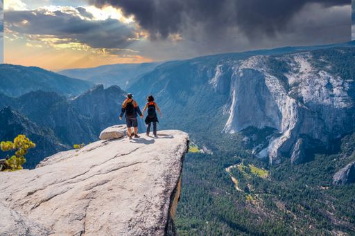 a couple at the Taft point trekking in Yosemite National Park at sunset in United States
