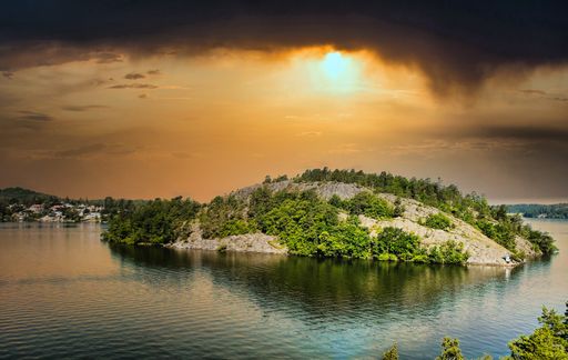 A small island with green trees in beautiful a sunset