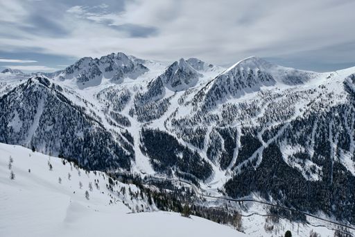 A high angle shot of a forested mountain covered in snow in Col de la Lombarde - Isola 2000 France