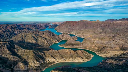An aerial view of the river in the canyon, surrounded by mountains