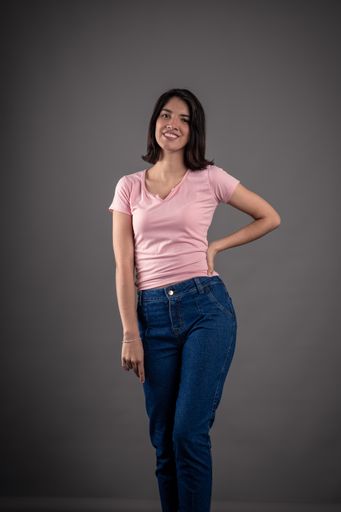 A vertical shot of a young female in pink with short hair posing on an isolated gray background