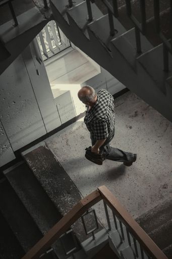 A vertical shot of a man goes down with stairs