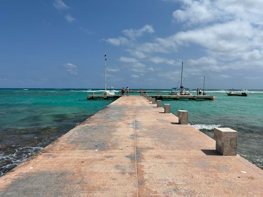 The sailboats in front of a pier on the sea