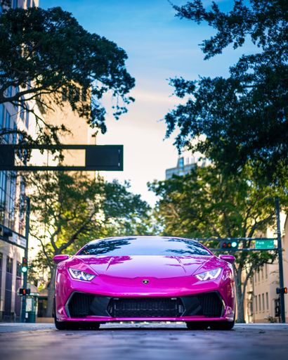 A vertical shot of a one of one Lamborghini Huracan with a carbon fiber body kit in a pink color