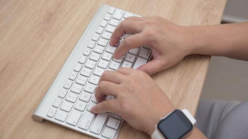 A high angle shot of female hands typing on a keyboard