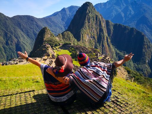 Beautiful couple admiring Machu Picchu mountain, Sacred Valley, and the surrounding peaks from above