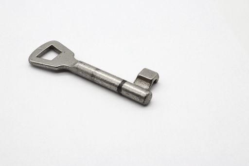 A metal key put on a clear white surface