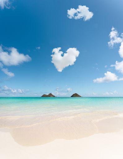 A vertical shot of a beautiful Lanikai Beach, Kailua in Hawaii, USA with a cloudy blue sky in the background