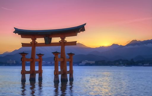 A floating torii gate on a lake at sunset