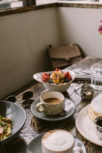 A vertical shot of cups of coffee and cookies on the table