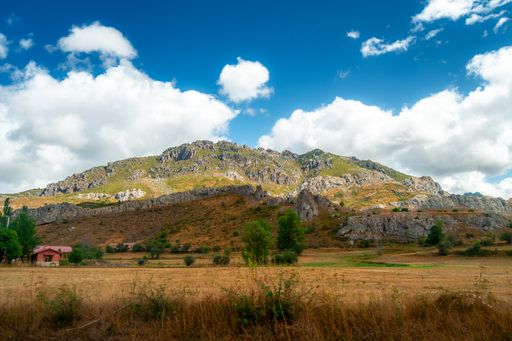 A scenic view of Asturias, Spain's rocky mountains on a cloudy day with vibrant colors