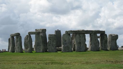 The Stonehenge on a cloudy day, surrounded by visitors.