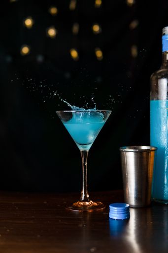 Close up view of a Blue cocktail with splashes when falling ice