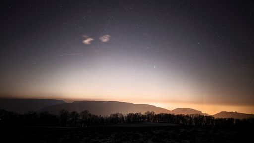 The moon shining over mountain and hilltop at night
