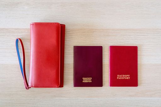 Top view of traveler accessories on beige background with passports and a wallet