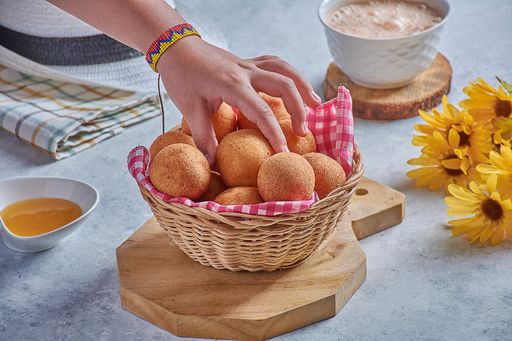 A closeup shot of a man hand getting at breakfast with bread and honey and coffee