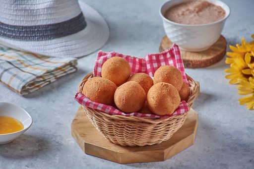 A high angle shot of breakfast table with bread and honey and coffee with a man hat in the corner