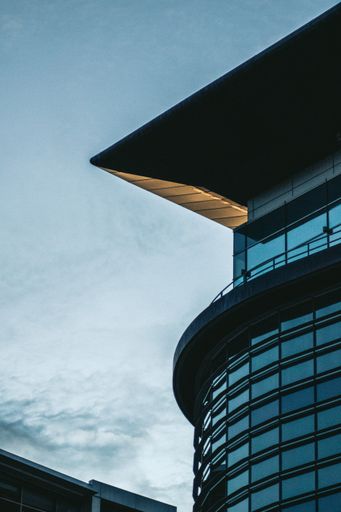 A vertical shot of a modern building and roof detail with blue sky in the background