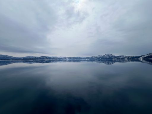 The beautiful view of Lake Tazawa with snowy mountains in the distance. Semboku, Akita, Japan