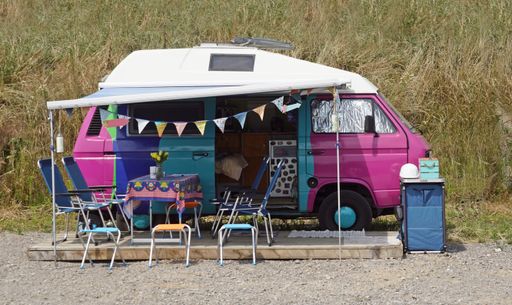 A closeup shot of a colorful hippie car as a house with a table and chairs