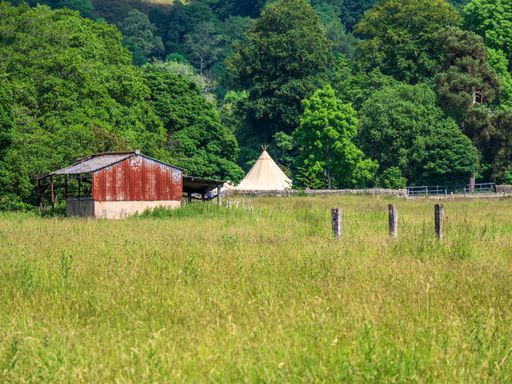A beautiful view of a green field with an old barn