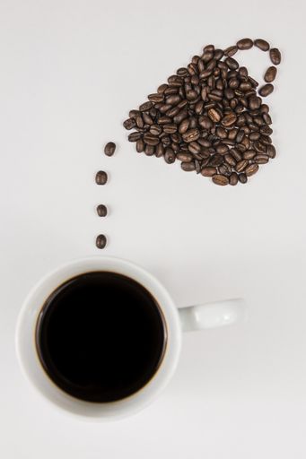 Overhead view of coffee beans and a cup of black coffee