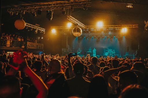 A nighttime concert scene with a crowd of spectators enjoying the show