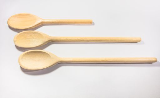 Three wooden spoons lined up on white background
