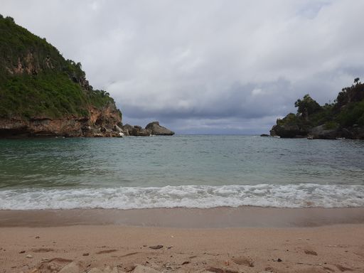 Lagoon view from sand beach to the sea, flanked from two green hills at Pantai Ngrenehan beach, Gunung Kidul, Yogyakarta, java, Indonesia.
