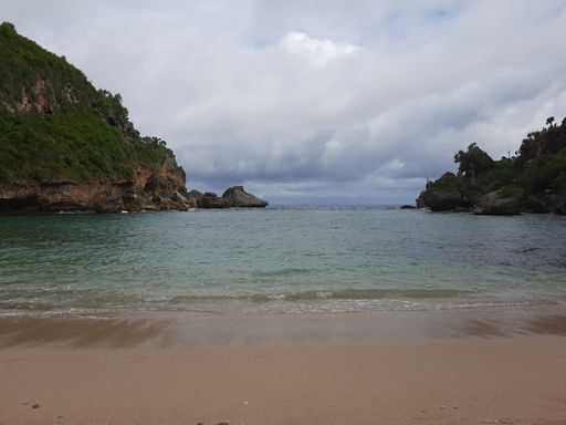 Lagoon view from sand beach to the sea, flanked from two green hills at Pantai Ngrenehan beach, Gunung Kidul, Yogyakarta, java, Indonesia.