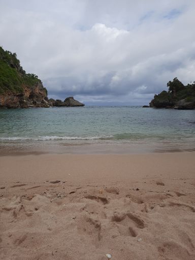 Lagoon view from sand beach to the sea, flanked from two green hills at Pantai Ngrenehan beach, Gunung Kidul, Yogyakarta, java, Indonesia.